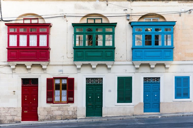 Traditional red, green and blue Maltese balconies on a townhouse in Sliema
